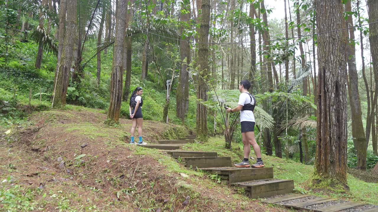 Asian couple taking photos during outdoor adventure in forest