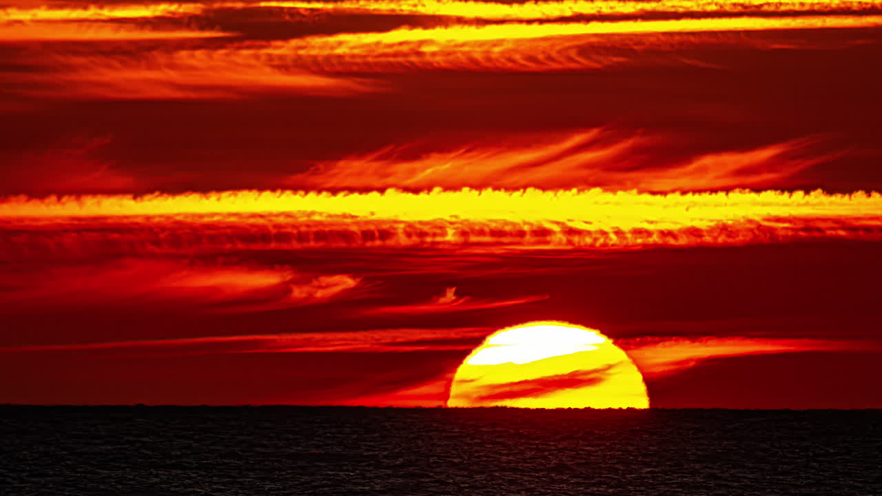 바다 위에서 극적인 해가 지는 모습
