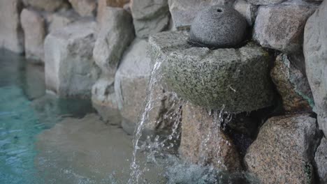 movimiento lento inclinarse hacia abajo desde la fuente de agua mineral caliente en el baño onsen japonés