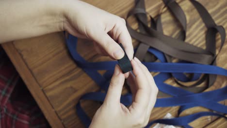 las manos de las mujeres toman una banda y la tuercen en un rollo.