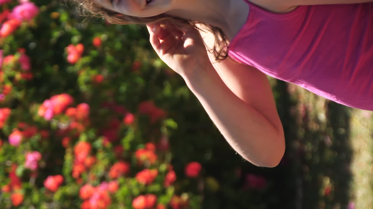 어린 소녀 가 입 에 신선 한 코코 조각 을 장난스럽게 던지고 있다