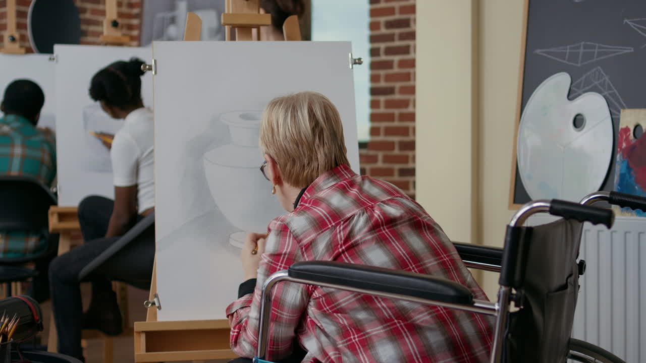 Senior woman in wheelchair drawing vase sketch with pencil