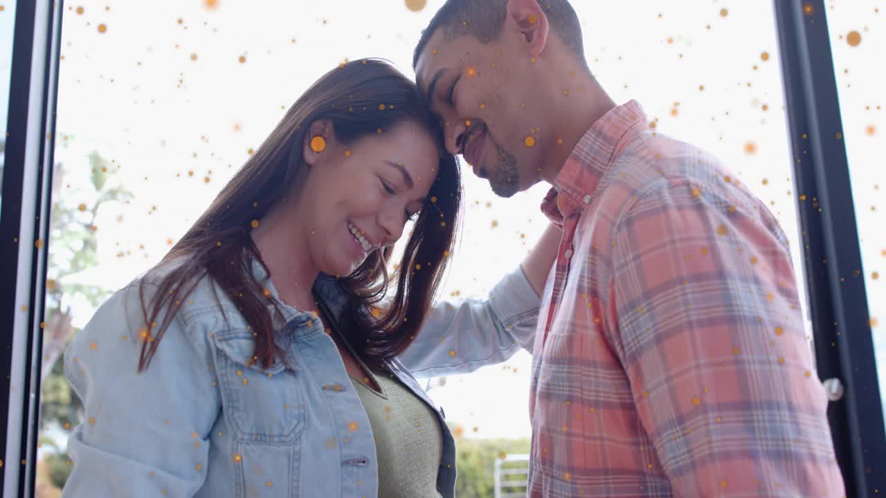 Pregnant woman and partner touching belly, pulling camera back while particles showing health bond