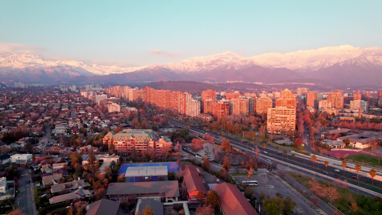 Luft-Parallaxenaufnahme von Las Condes und Vitacura, geteilt durch die Kennedy Avenue, schneebedeckte Berge, Santiago, Chile