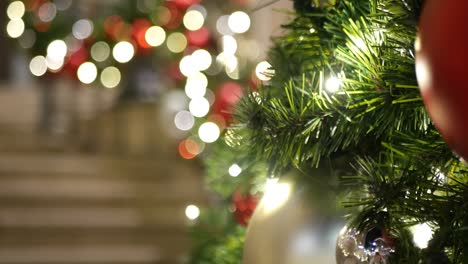 primer plano de un árbol de navidad al aire libre decorado festivamente con bolas rojas brillantes en un fondo de hadas brillantes borrosas. luces de guirnaldas desenfocadas, efecto bokeh. feliz navidad y feliz concepto de vacaciones.