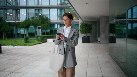 female executive type cellphone at downtown business center. focused woman hold