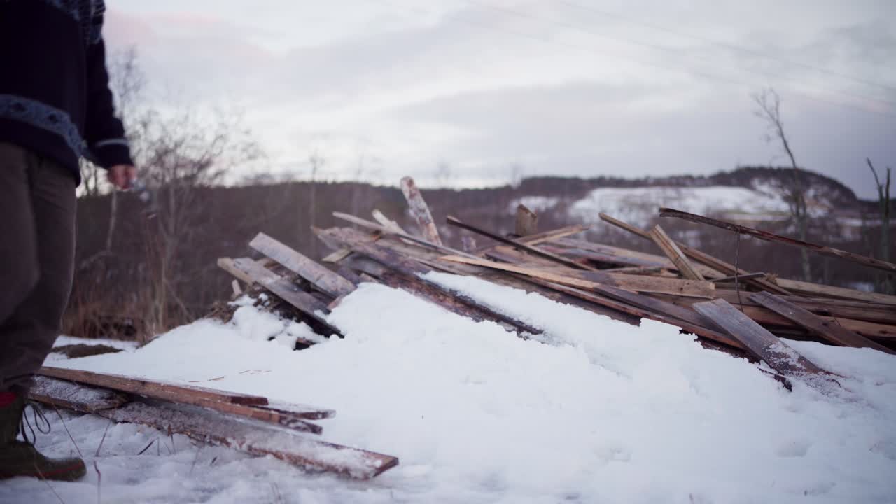 L'uomo sta impilando le assi di legno nella neve a Indre Fosen, Contea di Trondelag, Norvegia - Inquadratura statica