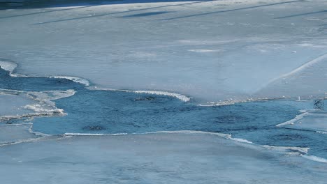 artificial water catchment reservoir for snow skiing slopes. winter time. frozen lake