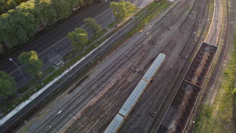 vista superior aérea sobre el tren amarillo que sale de la estación federico lacroze en buenos aires, argentina