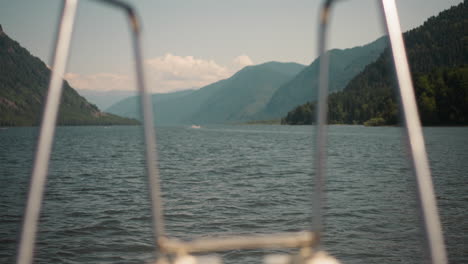 sailing contemporary motor boat along river between old mountains view from stern. yacht with metal railings sails in ocean gulf. exotic vacation