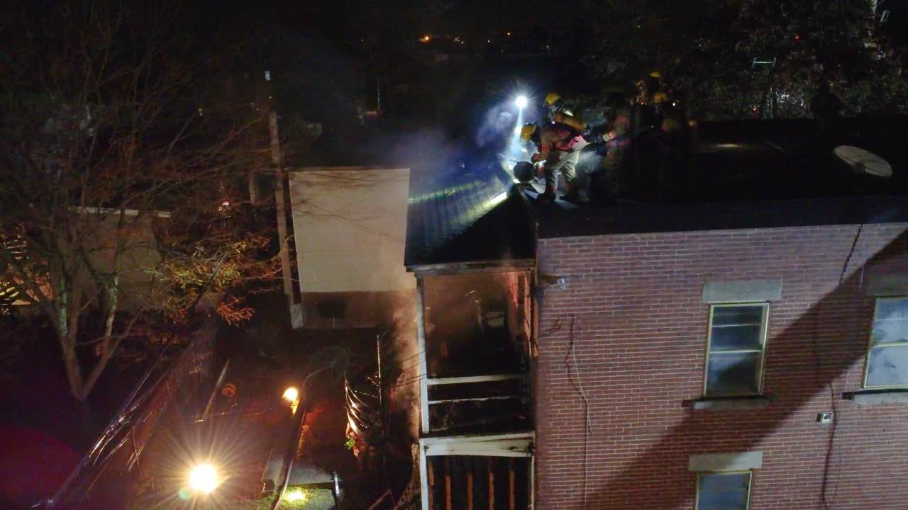 Firefighters on the roof during a fire in a residential building at night