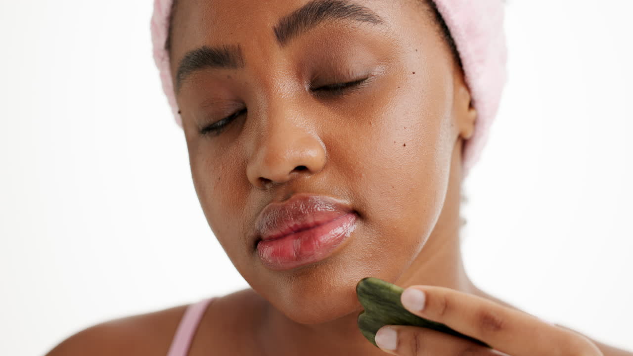 Woman using a gua sha for skincare