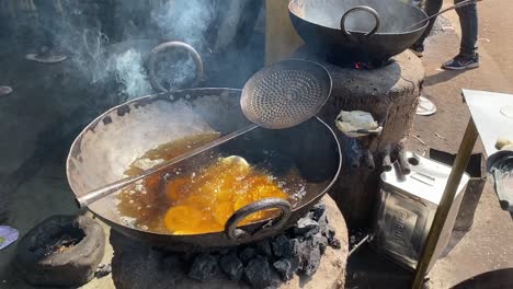 high angle shot over bengali lluchi frying in progress in a roadside stall in india on a bright sunny day