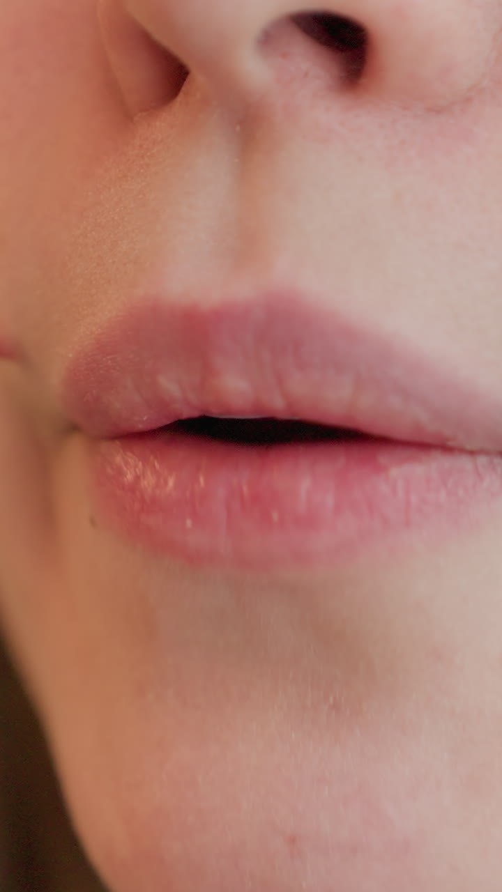 primer plano de labios caucásicos probando algo, cata al estilo nutricionista con una crítica reflexiva, una cuchara toca el labio y luego se retira, textura visible de la barbilla y el labio, evaluación tranquila en luz natural cálida