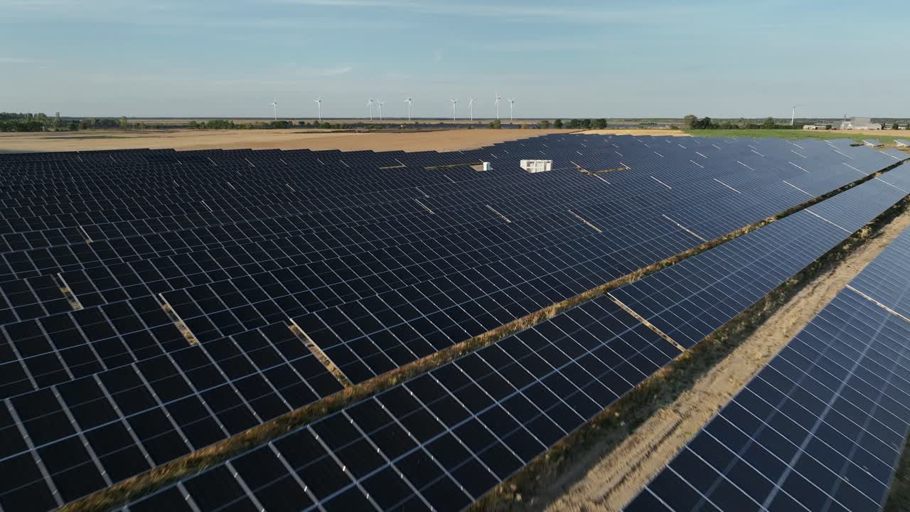 Drone flyver tæt på solpaneler i en fotovoltaisk basestation på en solskinsdag for at tjekke og teste effektiviteten.