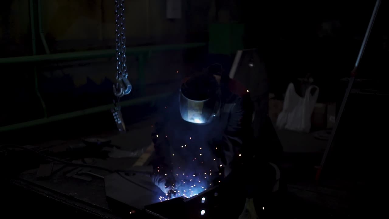 Welder at Work in a Dark Workshop