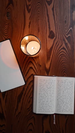 journal and candle on wooden table