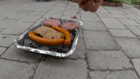 vista bloqueada de mini parrilla de barbacoa desechable con diferentes carnes