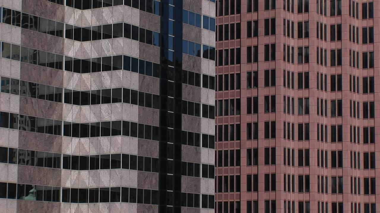 una mirada interesante a los colores y patrones que hacen dos edificios de gran altura y sus ventanas cuando se muestran uno al lado del otro