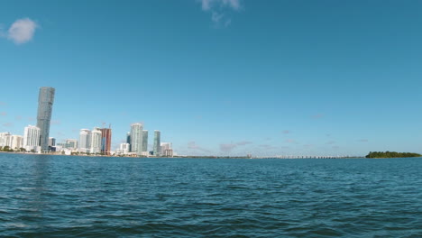 water level view from a small boat as it speeds toward miami in biscayne bay on a beautiful sunny day