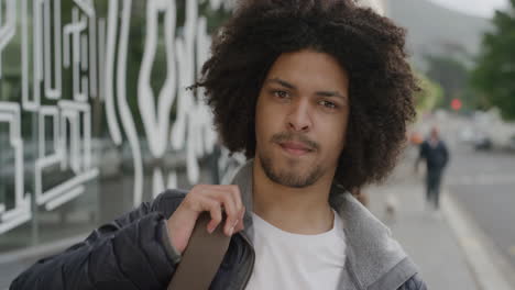 portrait of young mixed race man looking serious at camera male student commuter in urban city street background