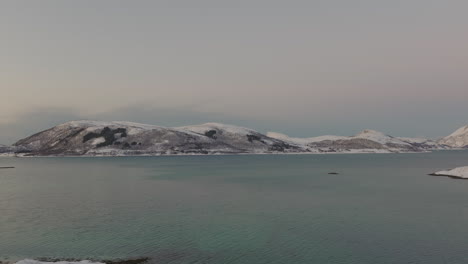 挪威冬天,kvaløya 島的空中景色,前景是平靜的海面