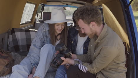 ein junger fotograf zeigt die bilder, die er während eines roadtrips zwei schönen jungen mädchen im wohnwagen gemacht hat 1