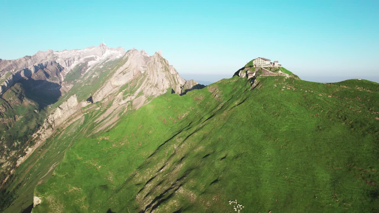 Luftfoto 4K droneudsigt over Schaeffler Hut alpehytte på toppen af en grøn bjergryg, panorama over Schweiziske Alper, vandredestination, dramatiske tinder, alpint sommerlandskab, rejseturisme landskab.
