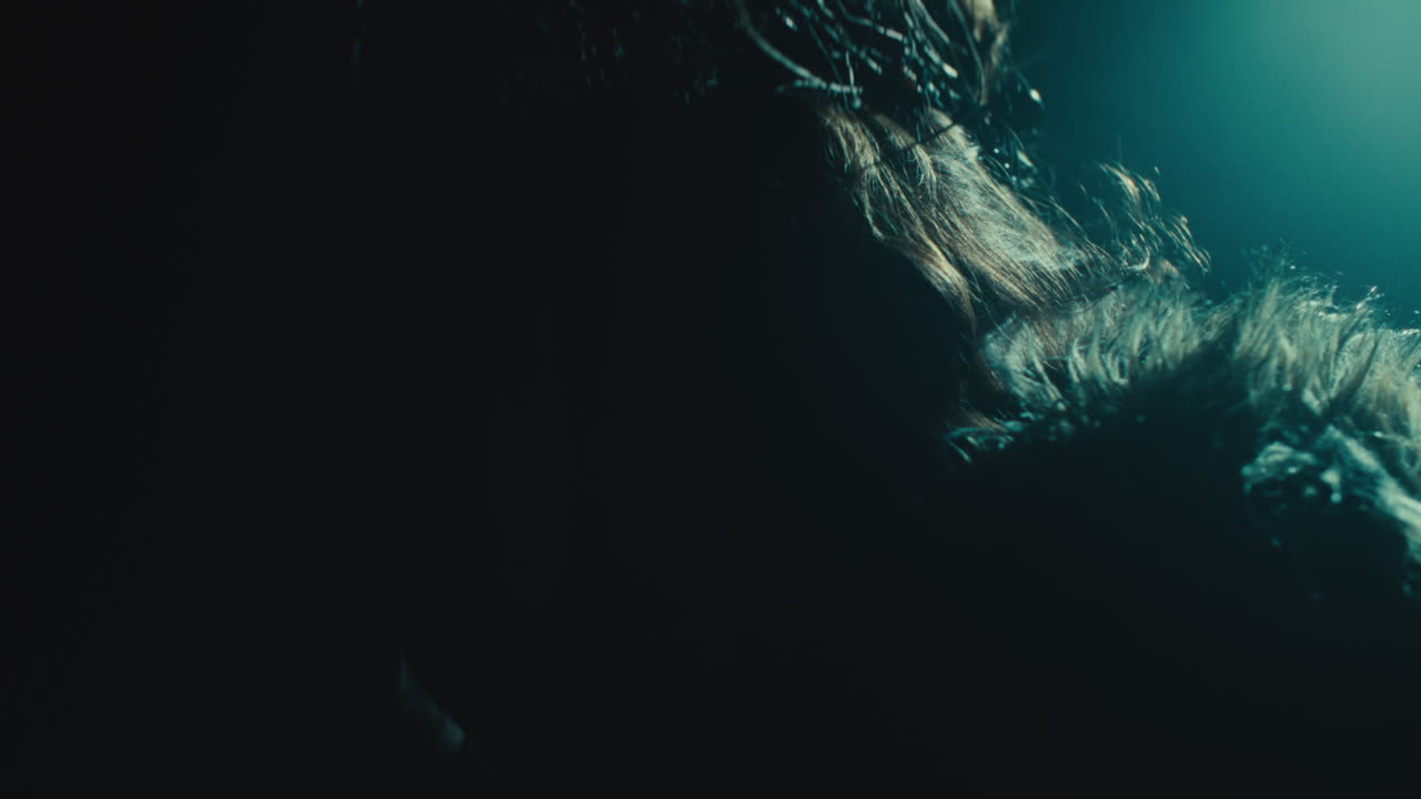 A creepy witch stands in the moody pose during the night storm