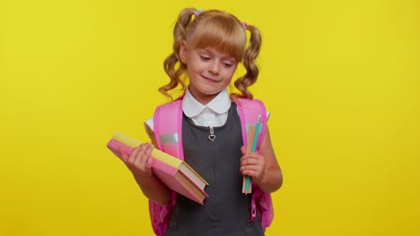 chica de escuela primaria con cola de caballo con uniforme sonriendo sobre un fondo amarillo
