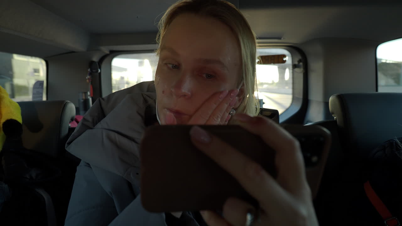 Kvinde lægger makeup-foundation i bilen