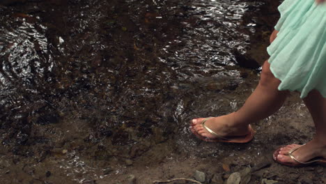 close up of female feet dipping in water