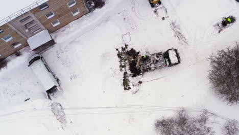 aerial birds eye view above workers with crane truck replacing damaged electricity pole by the apartment building