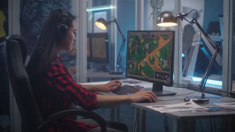 woman playing a strategy game at her workstation