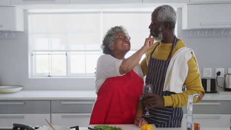 una pareja mayor afroamericana cocinando en casa. distanciamiento social en cuarentena