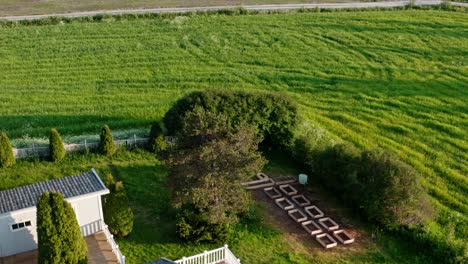 aerial view of farm house, plant beds and green fields in daytime