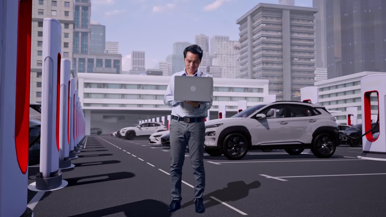 最新の都市型充電ステーションで電気自動車が充電される中、ノートパソコンを手に立ち、作業を続けるアジア人男性専門職の全身。