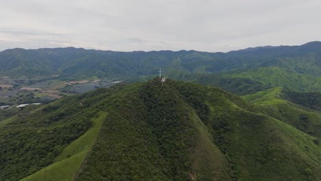 Metal-cross-monument-from-Hill-of-the-Cross-in-Tecalitlan-surrounded-by-green-mountain-range-and-clear-sky