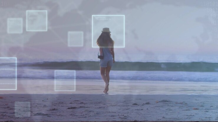 Žena kráčí k obzoru, zachycuje obsah, dosahuje mokrého písku, což způsobuje, že technologické čtverce rámují její hlavu.