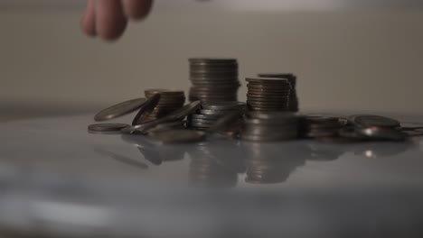 dropping coins onto a various stacks of other coins