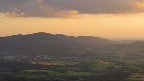 Blick-Auf-Eine-Berglandschaft-Bei-Sonnenuntergang,-Wenn-Die-Strahlen-Durch-Die-über-Dem-Berg-Liegende-Landschaft-Auf-Die-Felder-Scheinen-Und-Das-Tal-Mit-Gold-überflutet-Ist