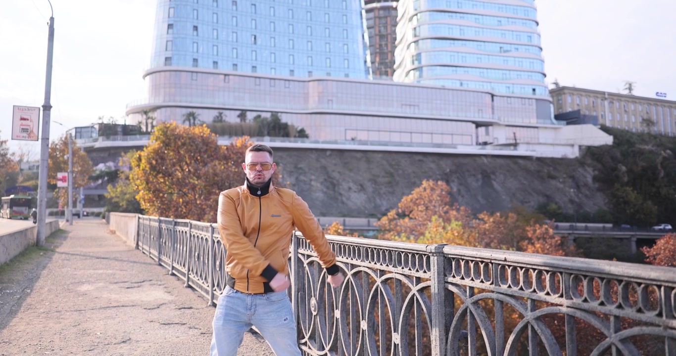 Ballerino fiducioso esegue street dance su un ponte urbano