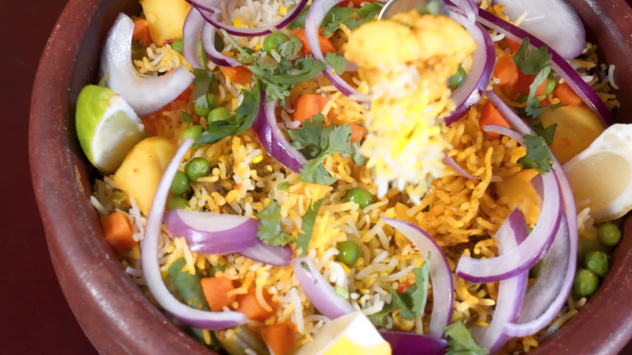 tenedor se sumerge en el tradicional indio hyderabadi dum biryani, cierra el control deslizante de cámara lenta 4k