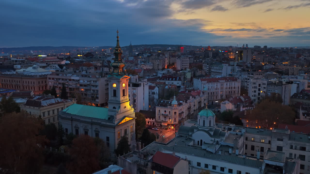 Aerial drone view of the historic center of Belgrade at sunset, featuring the illuminated Cathedral of St. Michael and the traditional architecture of Old Belgrade