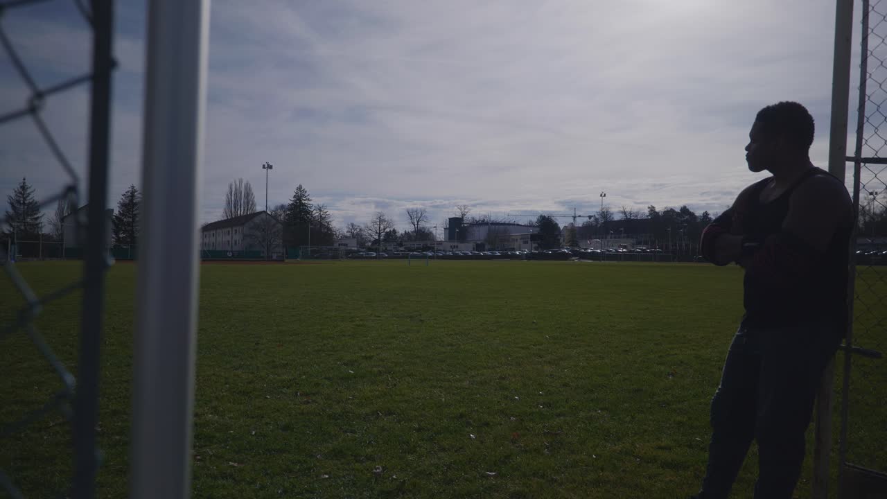 울타리 팔에 기대어 남자 - 4k에서 강한 운동 근육 흑인 남자 피트니스 야외 훈련 준비