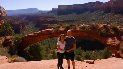 couple posing in front of devils bridge in sedona, arizona