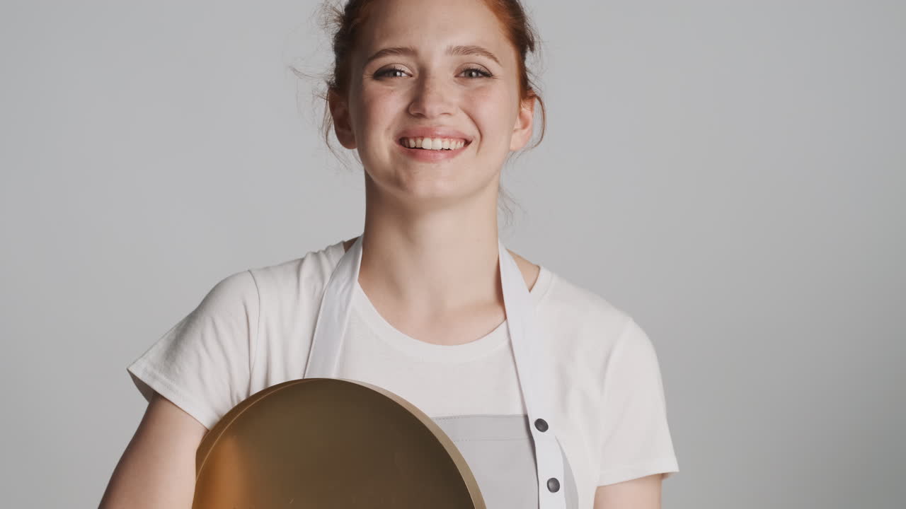 회색 배경에 카메라 앞에 은 머리 웨이트리스.