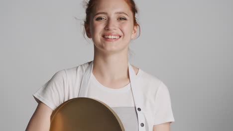 Redheaded-waitress-in-front-of-camera-on-gray-background.