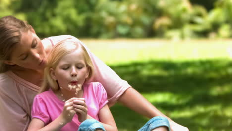 Madre-E-Hija-En-Cámara-Lenta-Soplando-Un-Diente-De-León