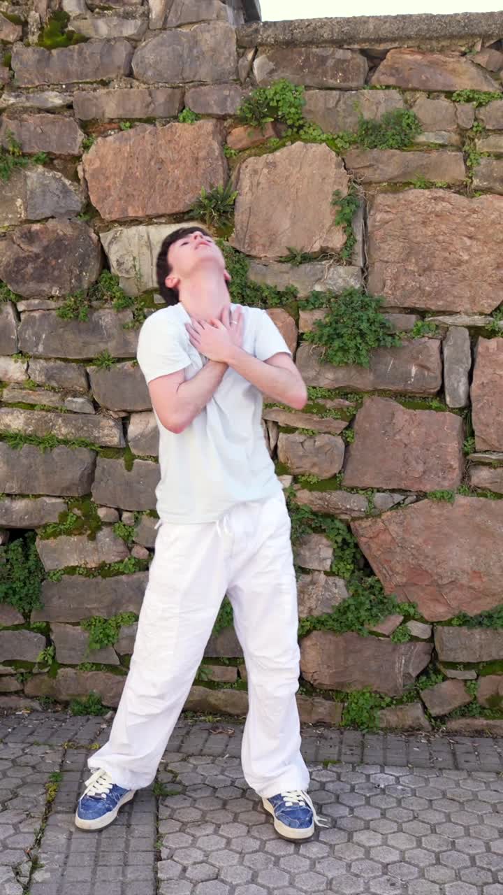 Una persona in piedi vicino a un muro di pietra